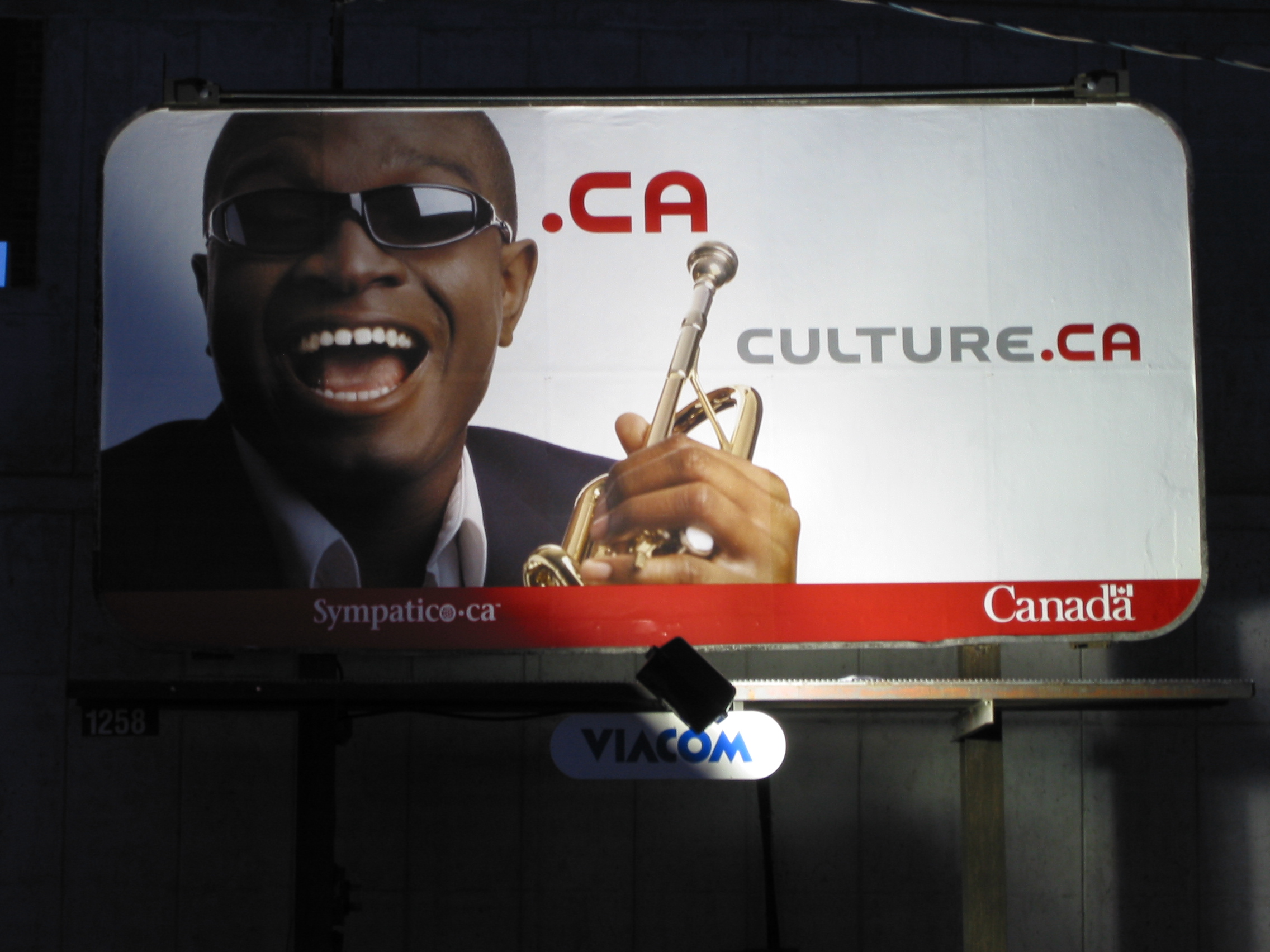 Photo of a billboard showing a man with a trumpet alongside the culture.ca branding