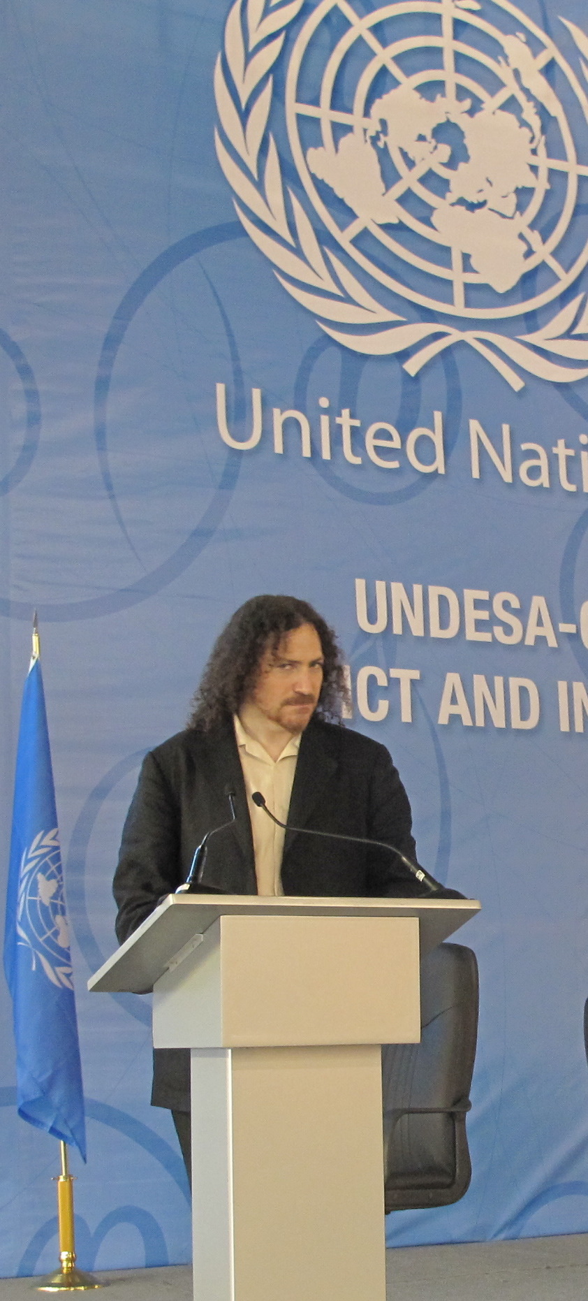 Photo of David Berman at the podium on a stage decorated with United Nations UNDESA and GAID branding