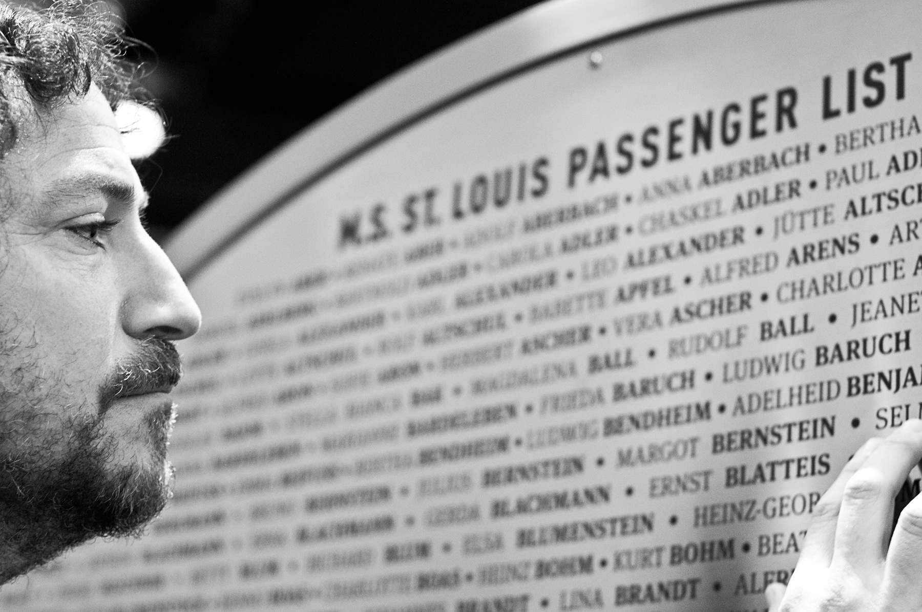 Image showing David reading the names of M.S St. Louis passenger list on the Wheel of Conscience