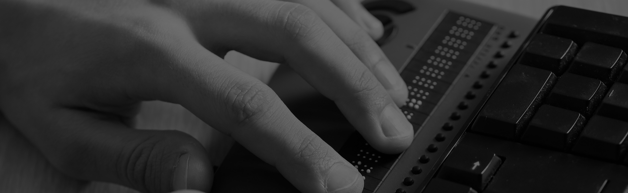 photo of fingers touching braille keyboard